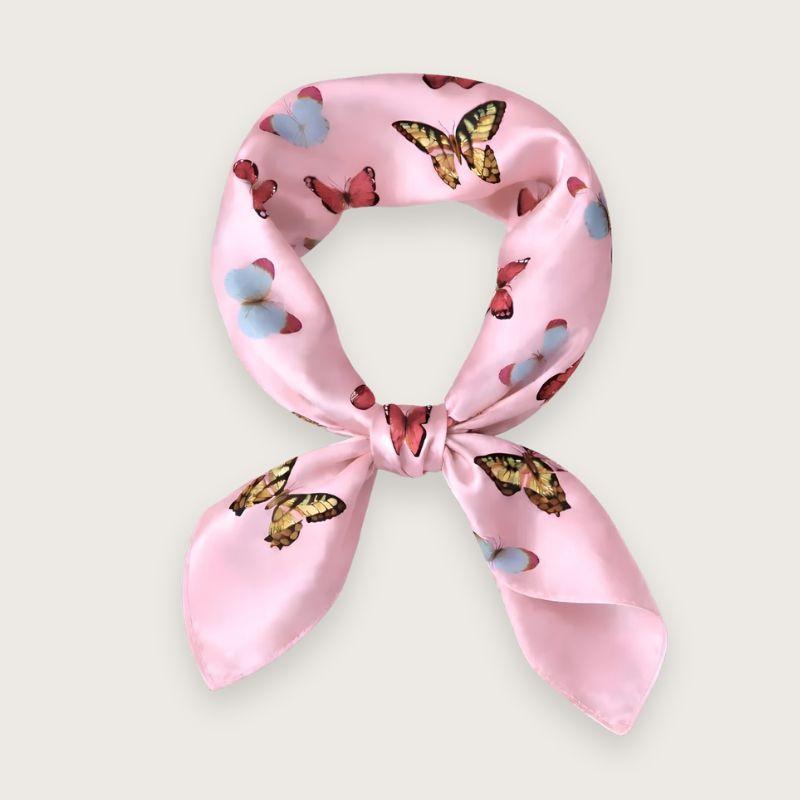 Lyserødt satintørklæde med sommerfugle i pink, blå og lilla nuancer. Y2K-inspireret satin scarf i silkeblanding med glossy finish og farverigt butterfly print. Trendy hårtørklæde og halstørklæde til kvinder, stylet med Scandinavian cool girl og Pinterest fashion vibe. Pink satintørklæde til styling om halsen, i håret eller på tasken. 60x60 cm satin tørklæde med 30% silke og 70% polyester.
Satin tørklæde med sommerfugle i 00'er-stil. Trendy satintørklæde. Lyserødt silketørklæde til halsen.