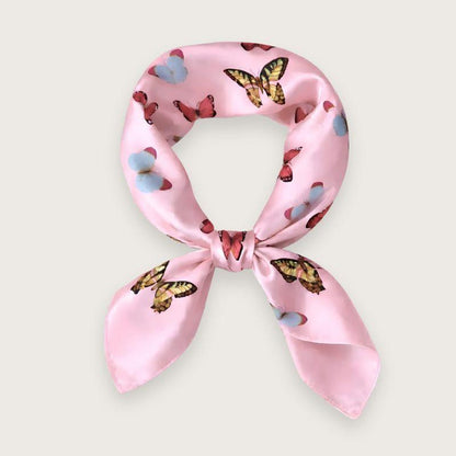 Lyserødt satintørklæde med sommerfugle i pink, blå og lilla nuancer. Y2K-inspireret satin scarf i silkeblanding med glossy finish og farverigt butterfly print. Trendy hårtørklæde og halstørklæde til kvinder, stylet med Scandinavian cool girl og Pinterest fashion vibe. Pink satintørklæde til styling om halsen, i håret eller på tasken. 60x60 cm satin tørklæde med 30% silke og 70% polyester.
Satin tørklæde med sommerfugle i 00'er-stil. Trendy satintørklæde. Lyserødt silketørklæde til halsen.