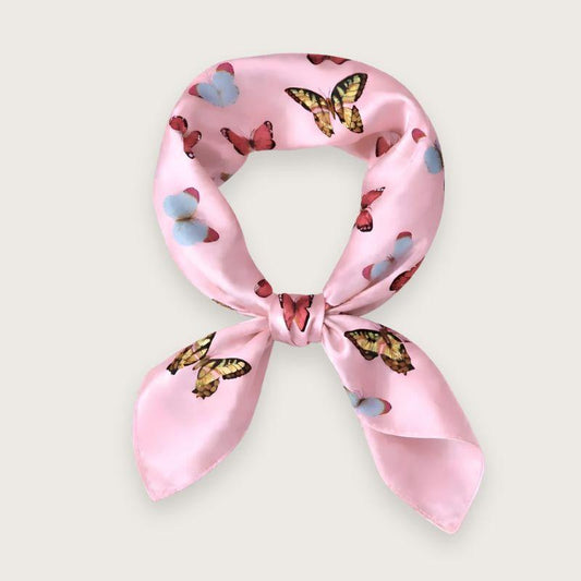 Lyserødt satintørklæde med sommerfugle i pink, blå og lilla nuancer. Y2K-inspireret satin scarf i silkeblanding med glossy finish og farverigt butterfly print. Trendy hårtørklæde og halstørklæde til kvinder, stylet med Scandinavian cool girl og Pinterest fashion vibe. Pink satintørklæde til styling om halsen, i håret eller på tasken. 60x60 cm satin tørklæde med 30% silke og 70% polyester.
Satin tørklæde med sommerfugle i 00'er-stil. Trendy satintørklæde. Lyserødt silketørklæde til halsen.