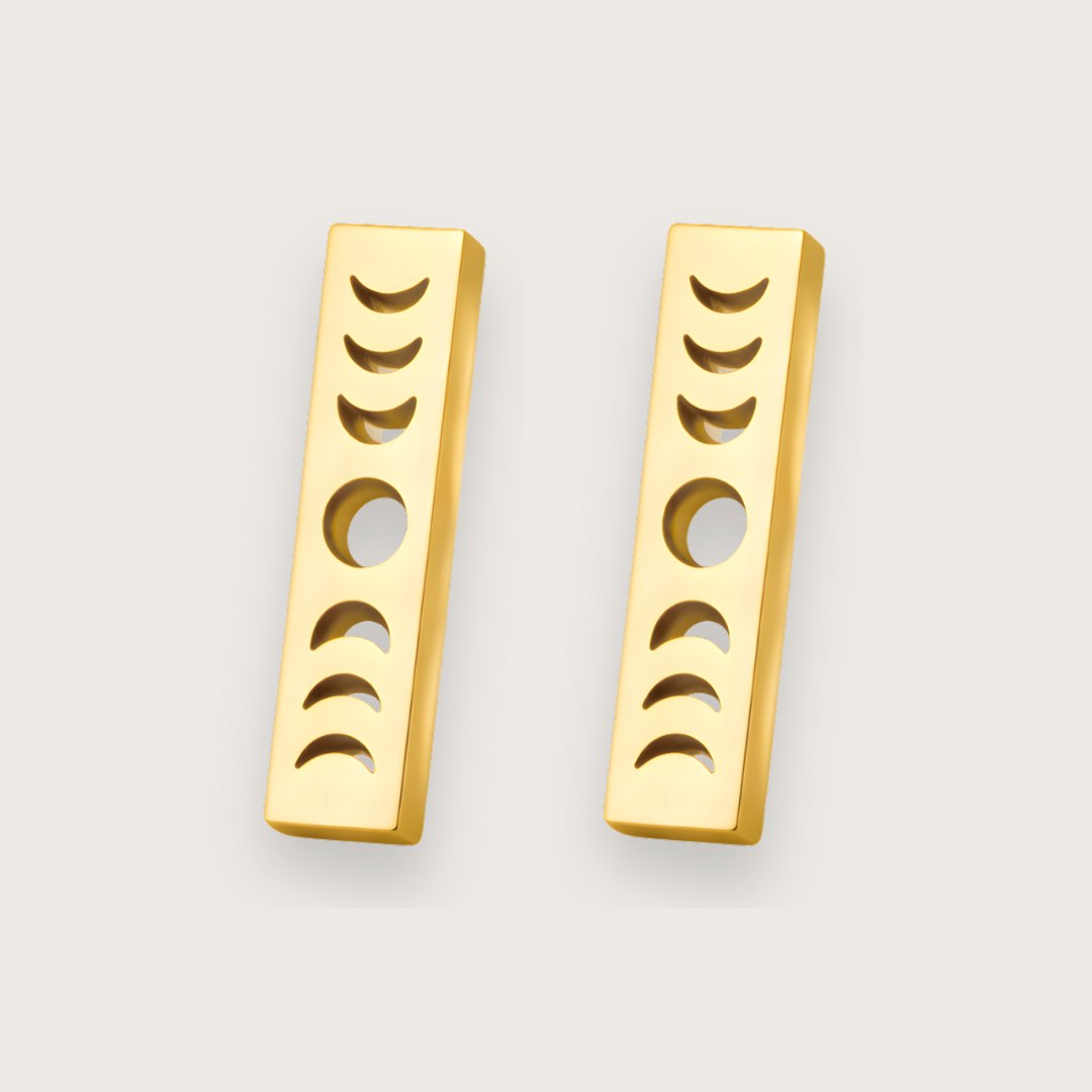 Smukke ørestikkere i 18k forgyldt stål.

De elegante Luna stav-ørestikkere med månefaser kombinerer et stilrent, geometrisk design med et dekorativt himmelmotiv. Den slanke, rektangulære form giver øreringene et moderne udtryk, mens de udskårne månefaser tilfører en fin detalje, der fanger lyset og giver smykket karakter.

Designet fungerer både minimalistisk og symbolsk. Månefasemotivet har længe været forbundet med naturens rytme og forandring. Månesmykker. Måneøreringe.