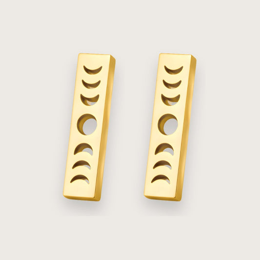Smukke ørestikkere i 18k forgyldt stål.

De elegante Luna stav-ørestikkere med månefaser kombinerer et stilrent, geometrisk design med et dekorativt himmelmotiv. Den slanke, rektangulære form giver øreringene et moderne udtryk, mens de udskårne månefaser tilfører en fin detalje, der fanger lyset og giver smykket karakter.

Designet fungerer både minimalistisk og symbolsk. Månefasemotivet har længe været forbundet med naturens rytme og forandring. Månesmykker. Måneøreringe.