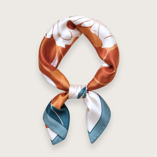 Klassisk satintørklæde med smuk orange pæon på blå og cremefarvet baggrund

Ruby er et satintørklæde med et enkelt og elegant blomstermotiv af en orange, udfoldet pæon med smukke petroleumsblå blade. Baggrunden er cremefarvet med en blå konstrastkant, der giver det satintørklædet eksklusivt look.

Satinen tilfører en diskret glans og falder smukt, når tørklædet bindes.

Brug tørklædet

Om halsen som et klassisk silketørklæde
Om hoften i ægte Y2K-stil