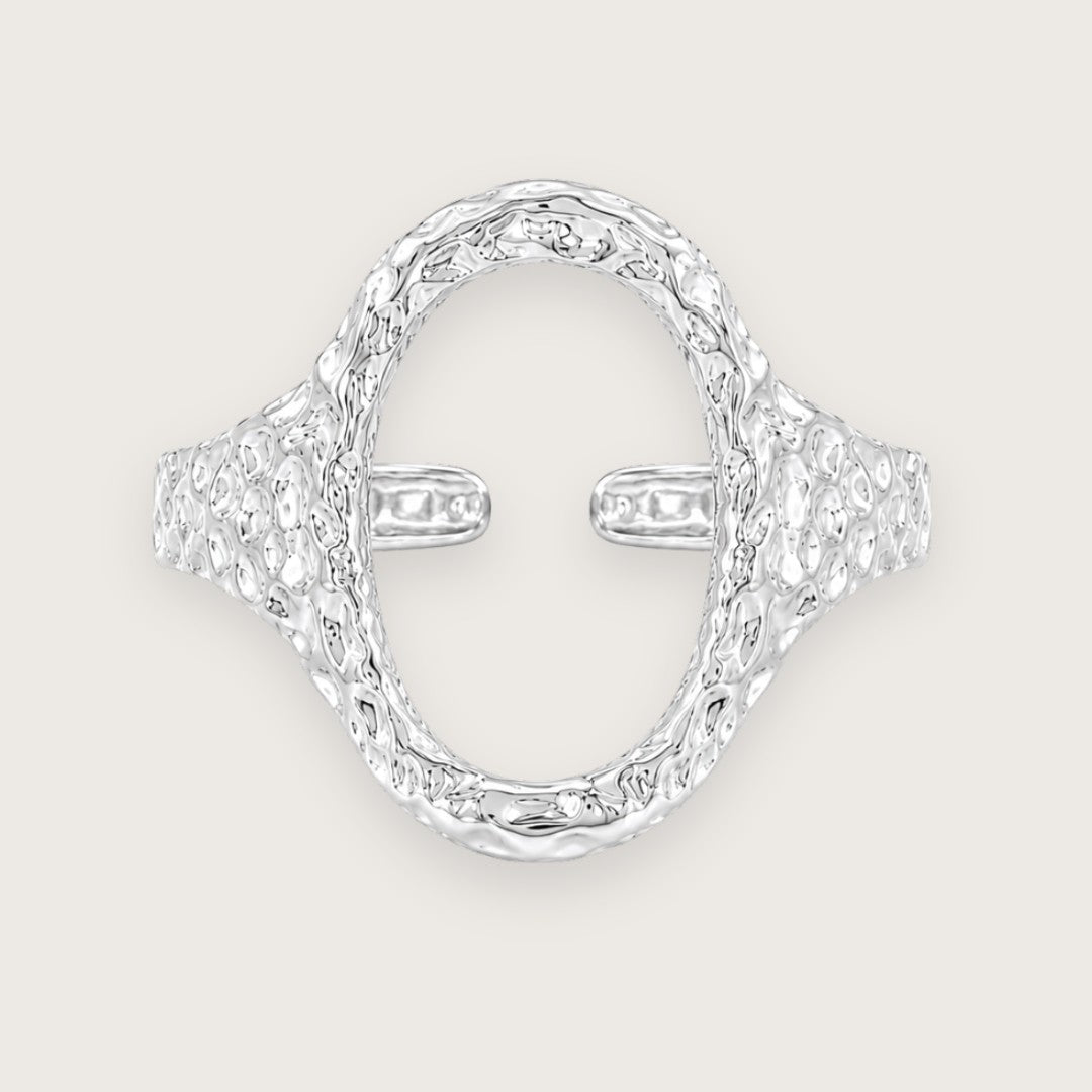 Sølvbelagt oval ring i rustfrit stål med banket overflade

Elvira-ringen er designet med en markant organisk silhuet og en åben oval front, der giver ringen et mere skulpturelt udtryk end klassiske sølvringe. Den hamrede overflade skaber ujævne refleksioner i metallet og giver ringen mere dybde, struktur og karakter fra alle vinkler.

Elvira er en sølvring, der tilfører form, struktur og mere kant til selv en enkel styling.

Ringen er fremstillet i stål med vandfast PVD-sølvbelægning.

oval sølvring 