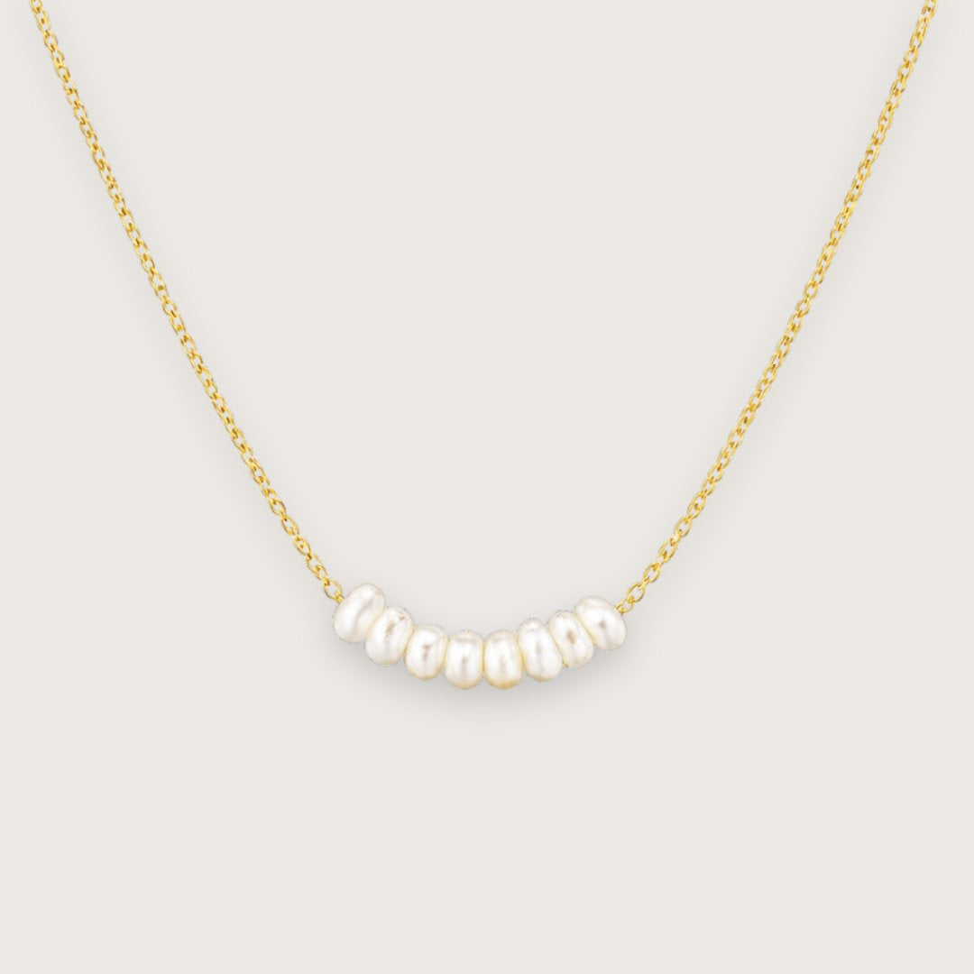 Smuk og klassisk 18k forgyldt halskæde med ferskvandsperler

Den elegante Calliope guldhalskæde med ferskvandsperler kombinerer klassisk perleæstetik med moderne funktionalitet.&nbsp;

De små naturlige ferskvandsperler ligger smukt samlet i midten af kæden og giver halskæden et let, feminint og tidløst udtryk, der fungerer lige godt til hverdag som til særlige begivenheder.

Halskæden er fremstillet i rustfrit stål med 18k PVD-forgyldning. Konfirmationssmykker, smykker til konfirmation, perlehalskaede, guld