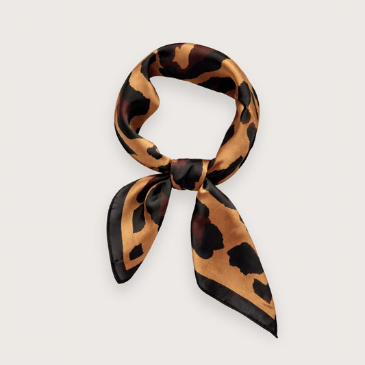 Matilda satintørklædet har et grafisk og diskret sort og brunt leoprint på en smuk gyldenbrun baggrund.&nbsp;

Et nordisk skandinavisk take på dyreprint-trenden.

Tørklædets udtryk er roligt og stilrent. Et kvadratisk tørklæde i satin, der er nemt at style til både minimalistiske hverdagslooks og mere skarpe, moderne outfits.

Satinen tilfører en diskret glans, som minder om silke og falder smukt, når tørklædet bindes.

Kvadratisk tørklæde med leopardmønster

silketørklæde med leoprint - satin tørklæde 