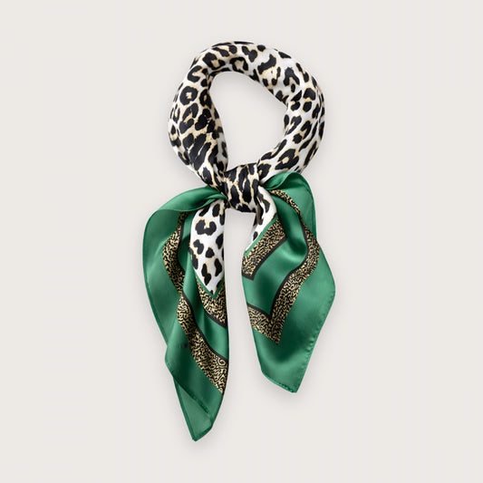 art noveau-agtigt udtryk og blander tiderne med det moderne dyreprint og den klassiske grønne farve.

Et smukt og trendy take på et klassisk silketørklæde med leopardmønster.

Det afdæmpede leopardmønster i varme nuancer af brun, karamel og sort er blødt og harmonisk og mindre larmende end traditionelle silketørklæder med leopardmønster.

Satintørklædet fremstår glat og let skinnende, hvilket giver en elegant finish uden at virke prangende. 
Satin tørklæde, silketørklæde, leoprint, leopard, smaragdgrøn.