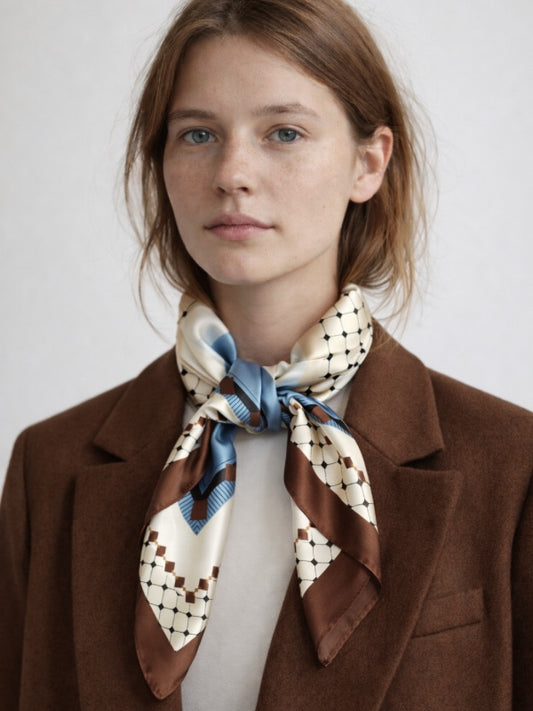 Klassiske, kvadratiske tørklæder kan bruges på utallige måder. Bind tørklædet om håret, brug det som en smuk detalje på tasken, som pandebånd, som klassisk tørklæde om halsen, eller gør lidt ekstra ud af frisuren ved at binde tørklædet om din knold eller hestehale.

Satintørklæder er et must i enhver garderobe.

Rhiannon satintørklæde til kvinder - brun kant med petroleumsblåt, hvidt og beige mønster.